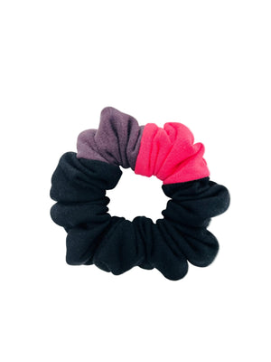 A scrunchie in black, pink, and purple on a white background