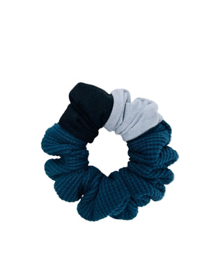 a scrunchie in black, blue, and gray on a white background