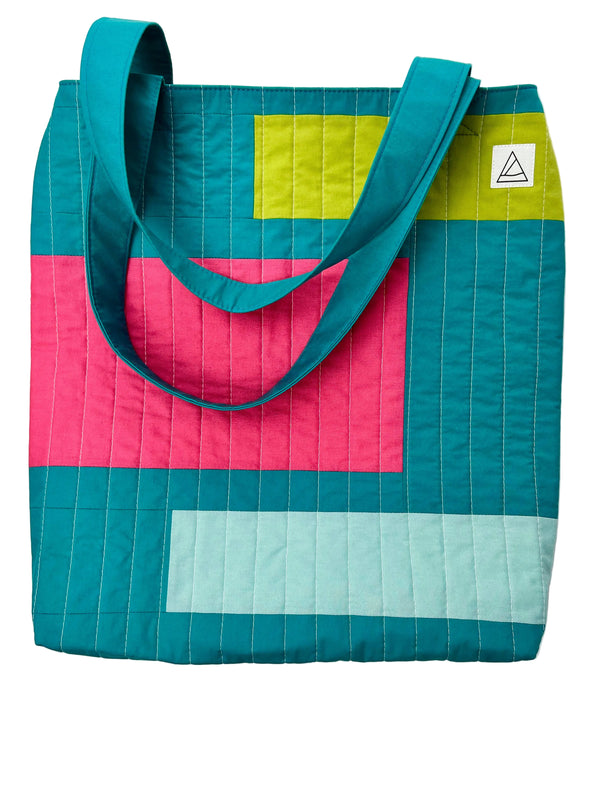 Colorful quilted tote bag with geometric pattern on a white background