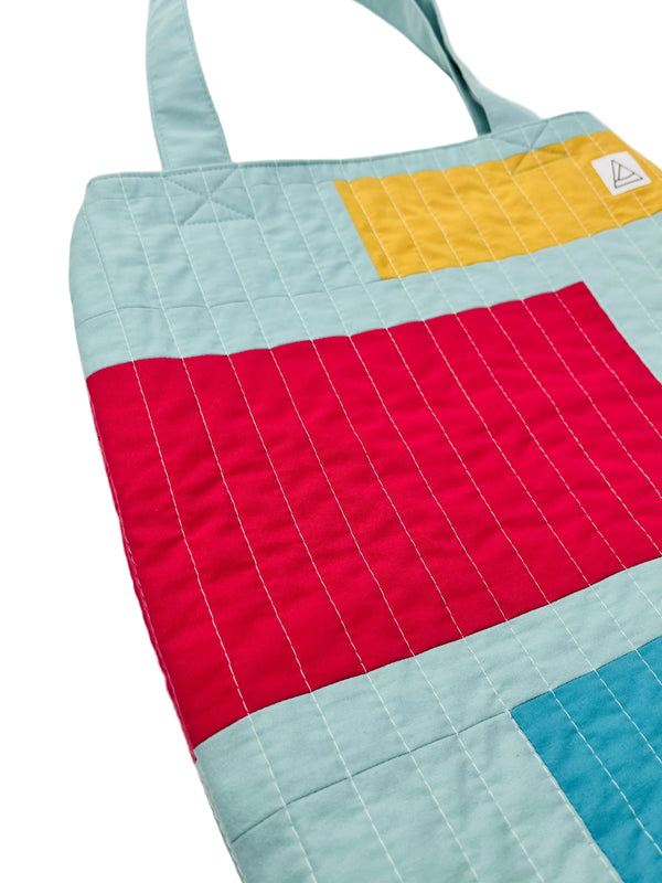 Colorful quilt with geometric patterns on a light background