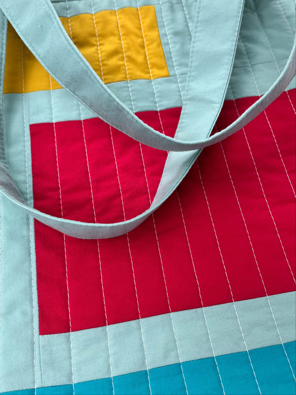 Close-up of a quilt with geometric patterns and a strap