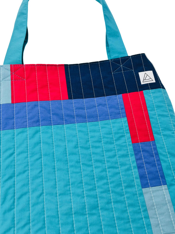 Colorful quilted bag with a geometric pattern on a white background