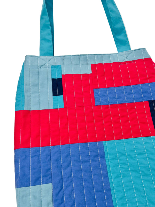 Colorful quilt with geometric pattern on a white background