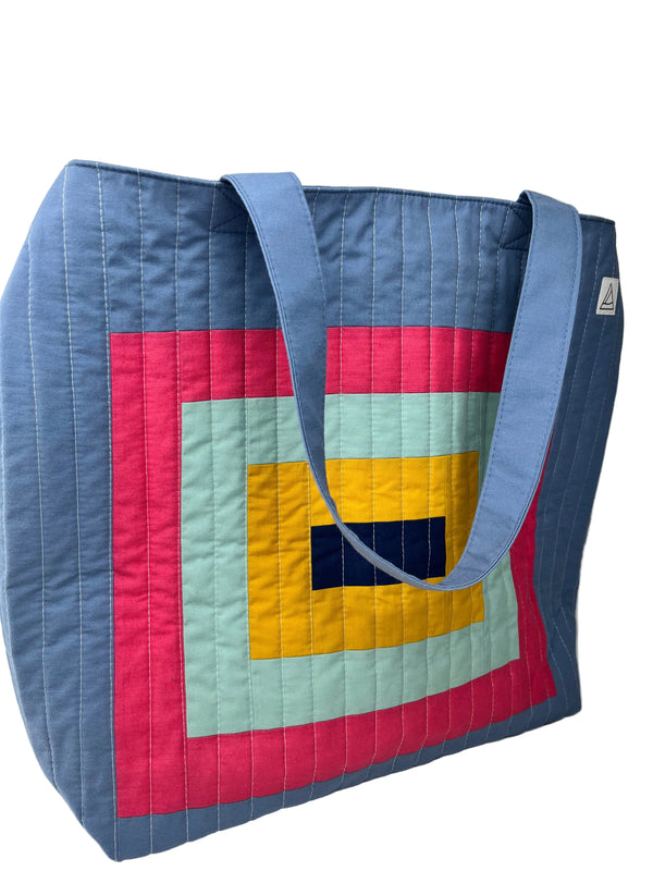 Colourful quilted beach bag with geometric pattern on a white background