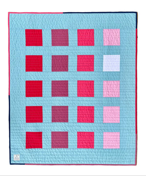 Quilt with a pattern of squares on a wooden surface