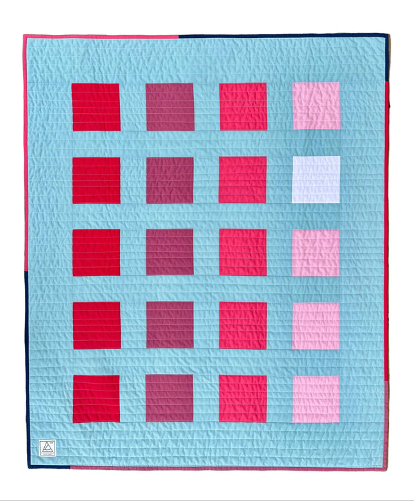 Quilt with a pattern of squares on a wooden surface