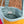 Colourful quilted bag with a brand label on a blurred natural background