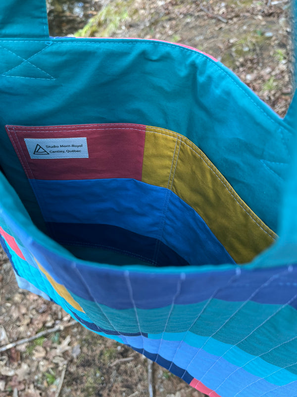 Close-up of a colorful quilted fabric with geometric pattern on a natural background